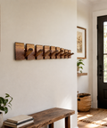 Wooden wall coat rack with reinforced fold away hook construction